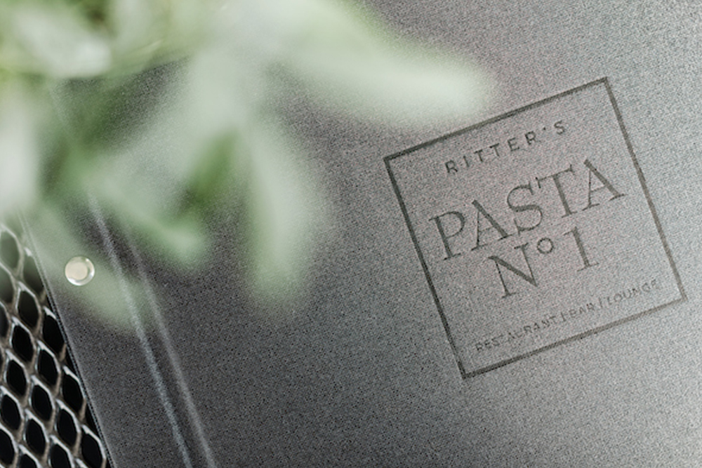 Close-up of a menu with the words "Pasta No 1" against a blurred background.